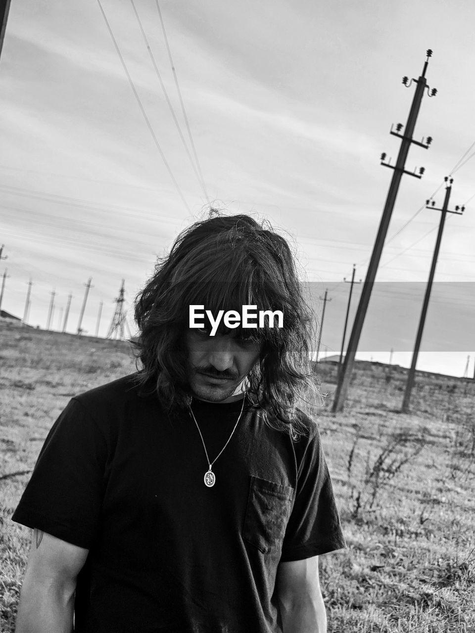 Portrait of man standing on land against sky