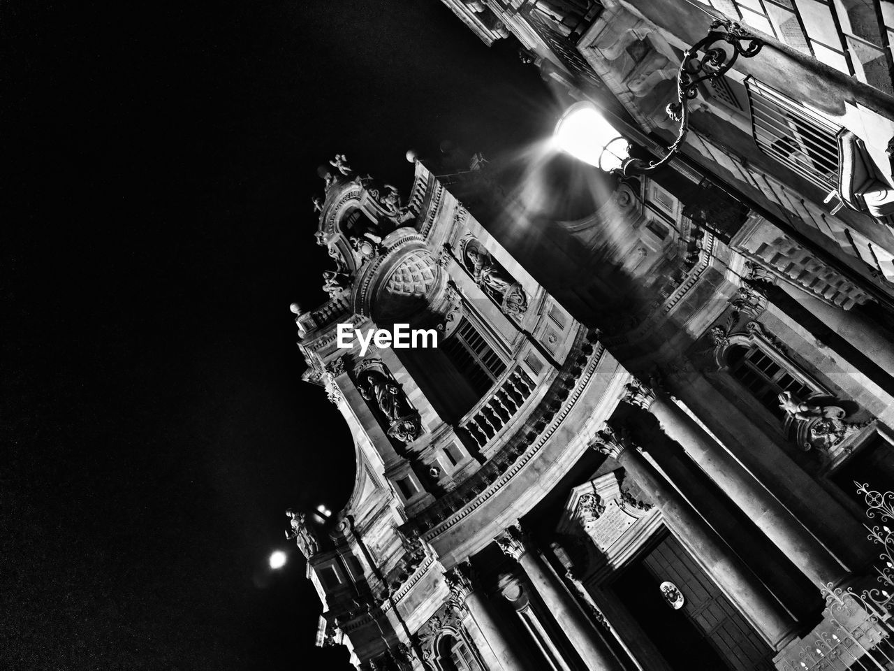 LOW ANGLE VIEW OF ILLUMINATED HISTORIC BUILDING AT NIGHT