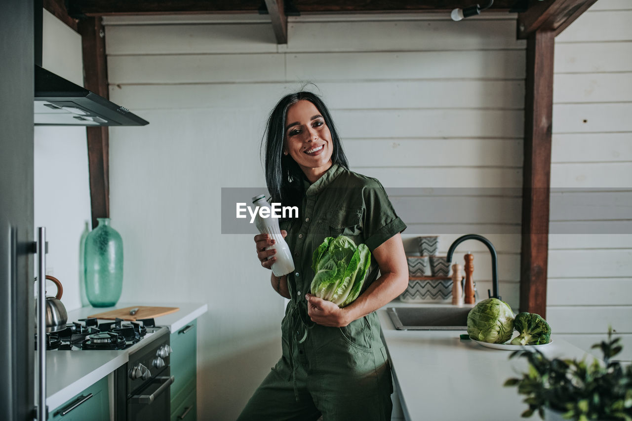 Full length of a smiling young woman standing at home