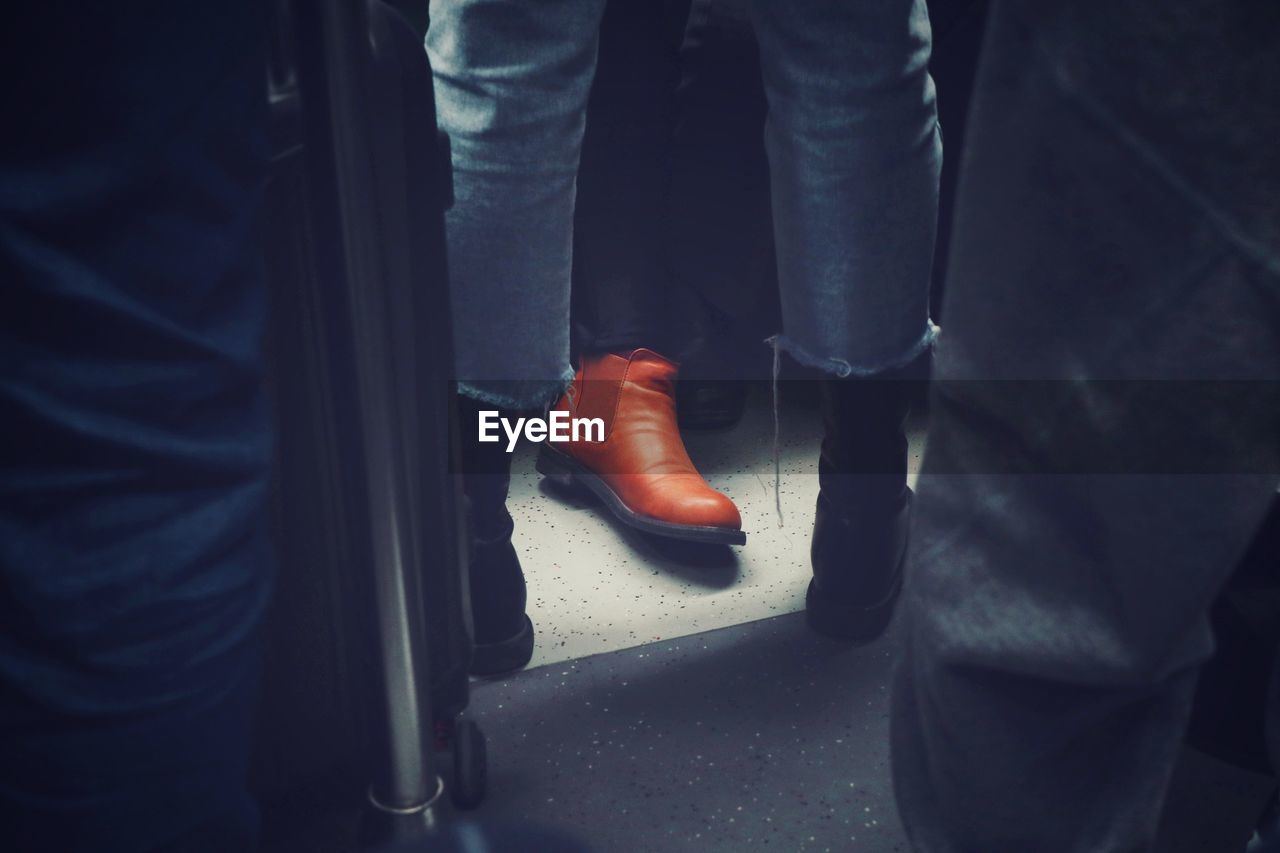 Low section of man wearing shoe sitting in train