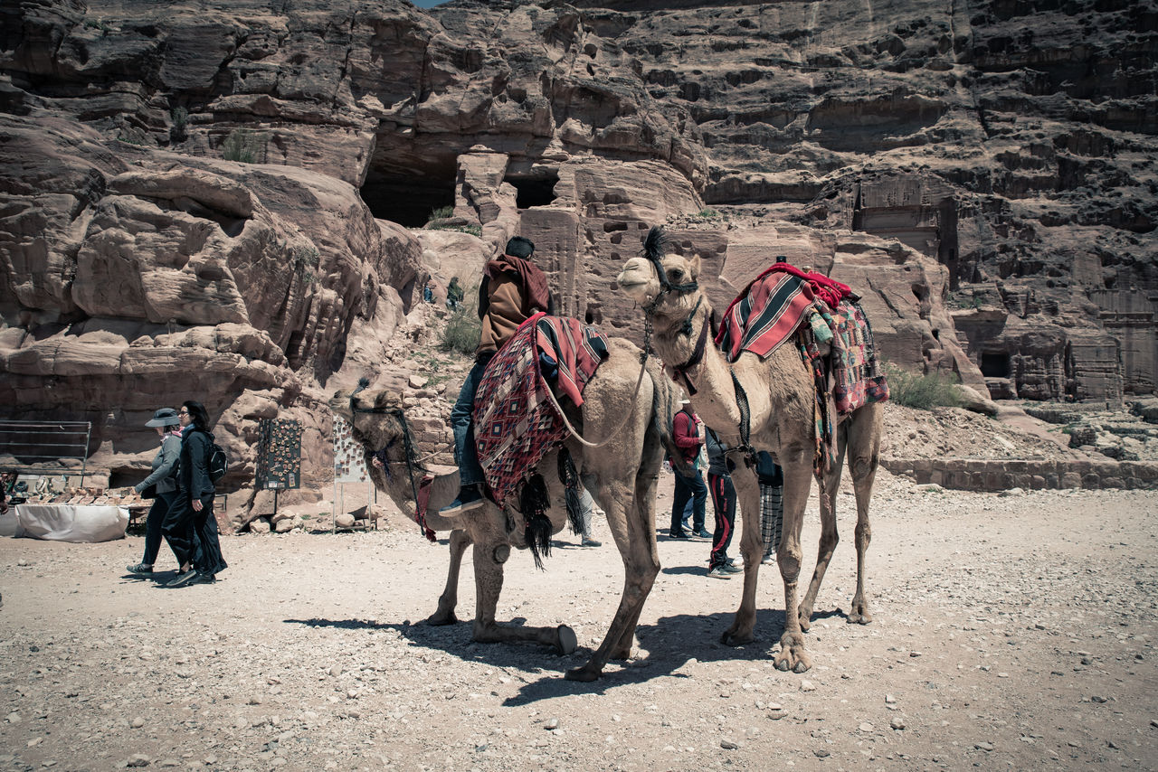 PEOPLE WALKING ON ROCK FORMATION