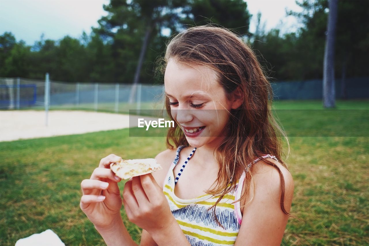 Close-up of girl eating food in park