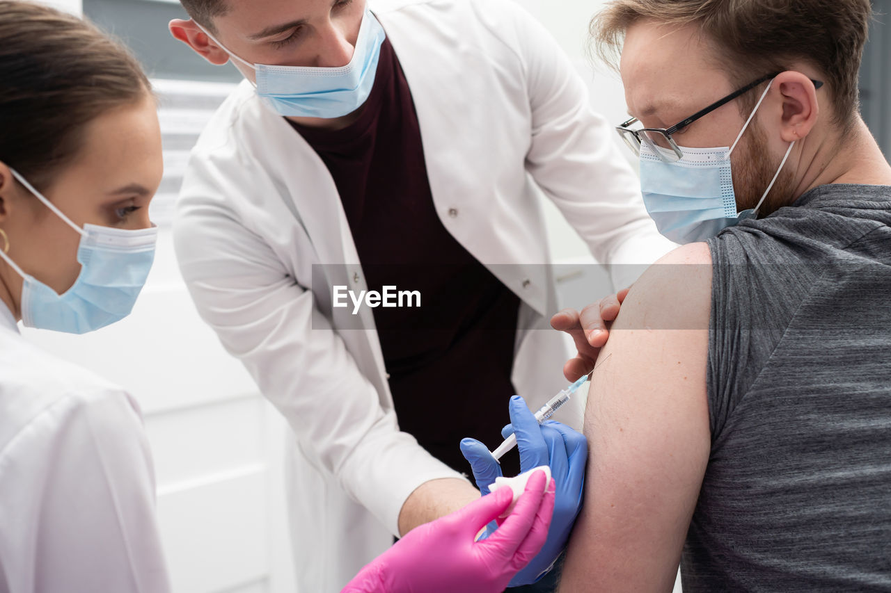 midsection of doctor examining patient in clinic