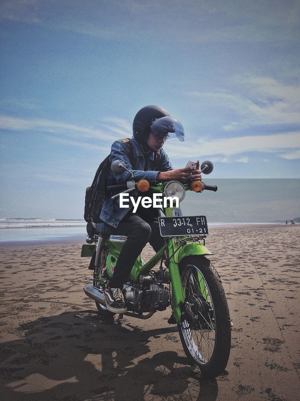 MAN RIDING MOTORCYCLE ON BEACH