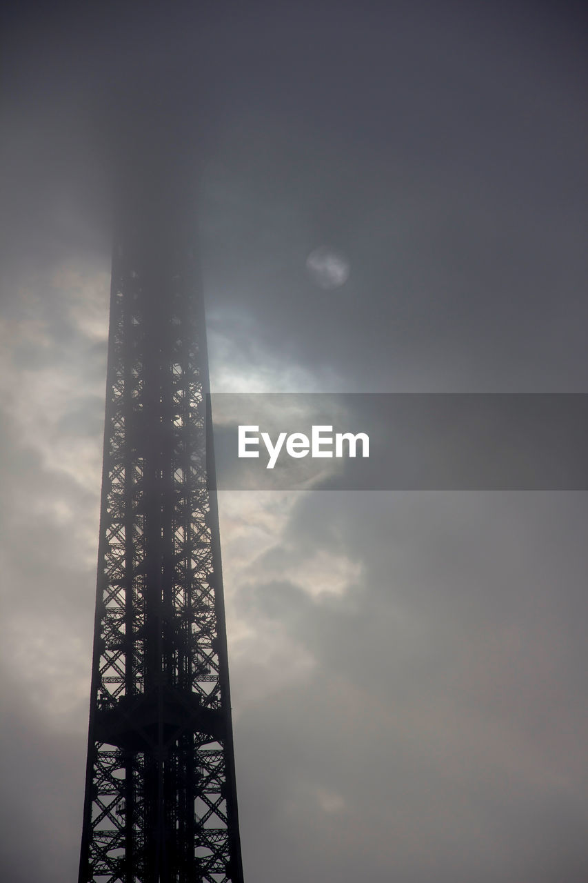 Low angle view of eiffel tower against cloudy sky at dusk