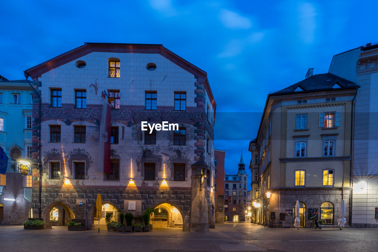 STREET AMIDST BUILDINGS AT NIGHT