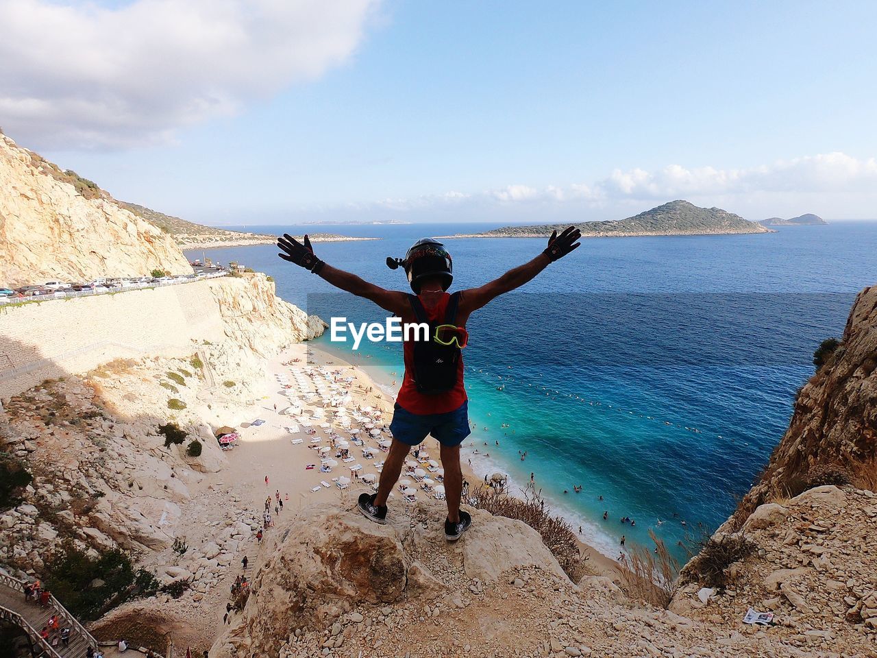 FULL LENGTH OF MAN STANDING ON ROCK AT BEACH