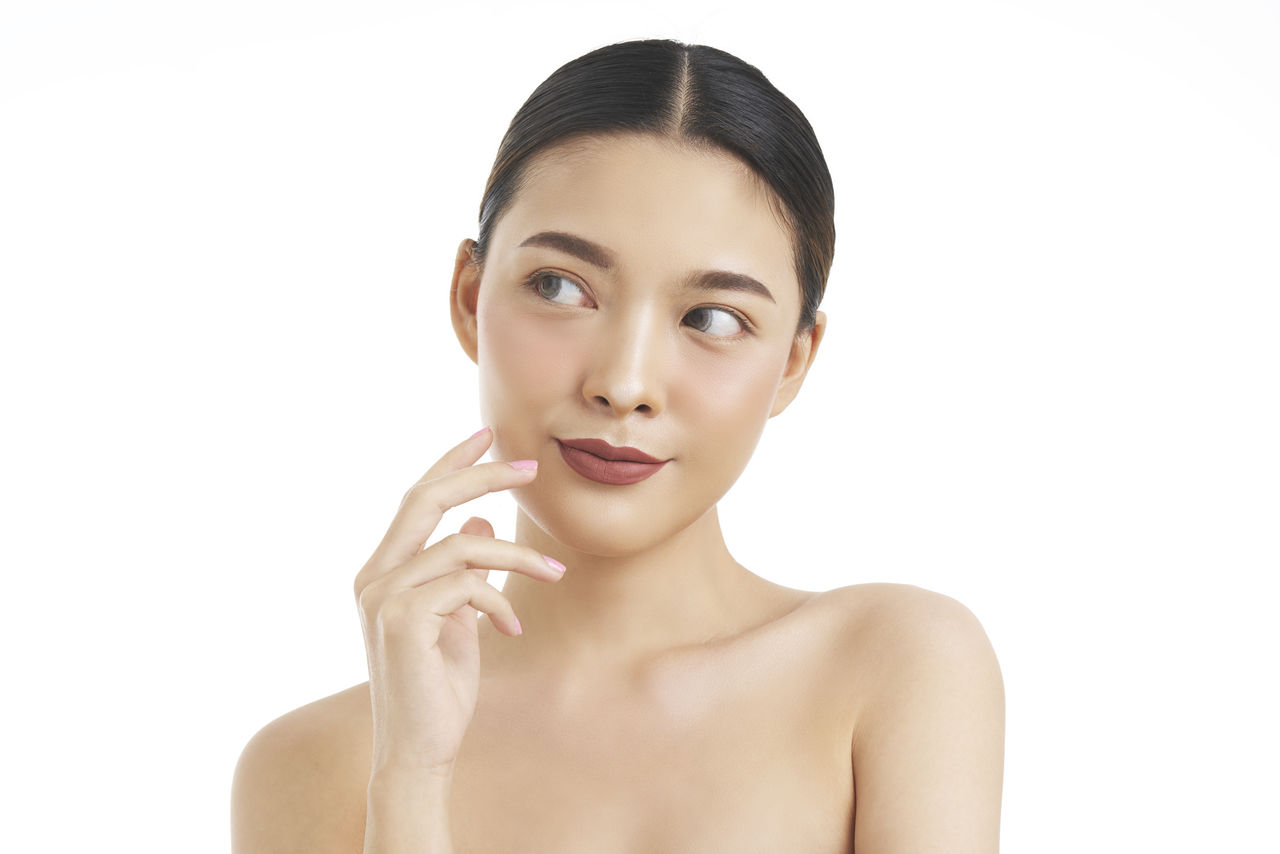 Close-up of thoughtful young woman over white background