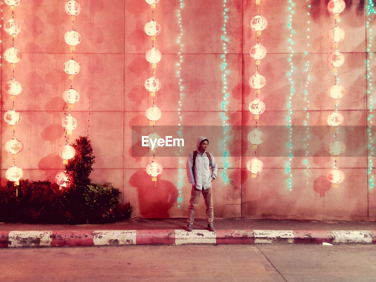 DIGITAL COMPOSITE IMAGE OF MAN STANDING BY WALL