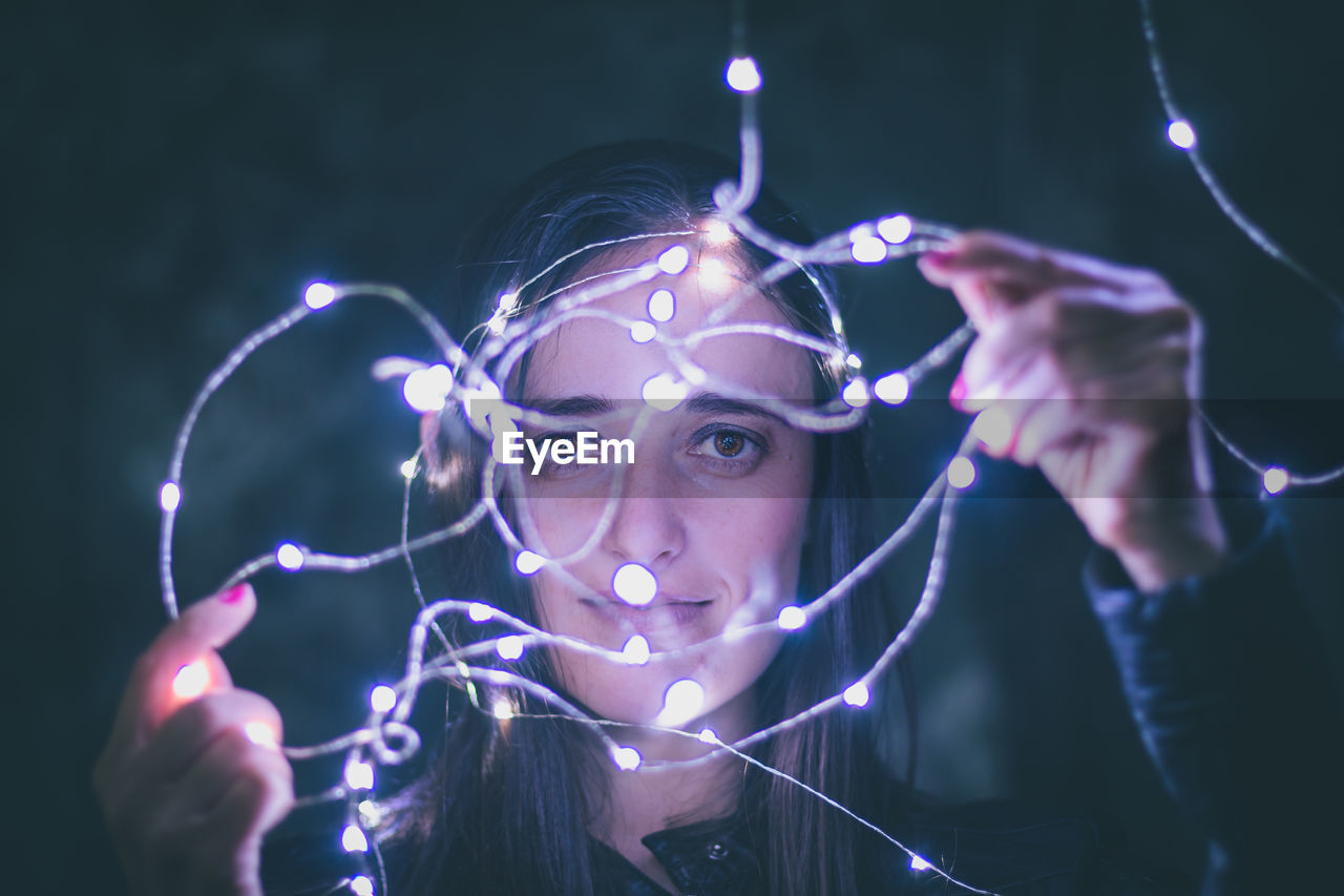 Close-up woman holding fairy lights