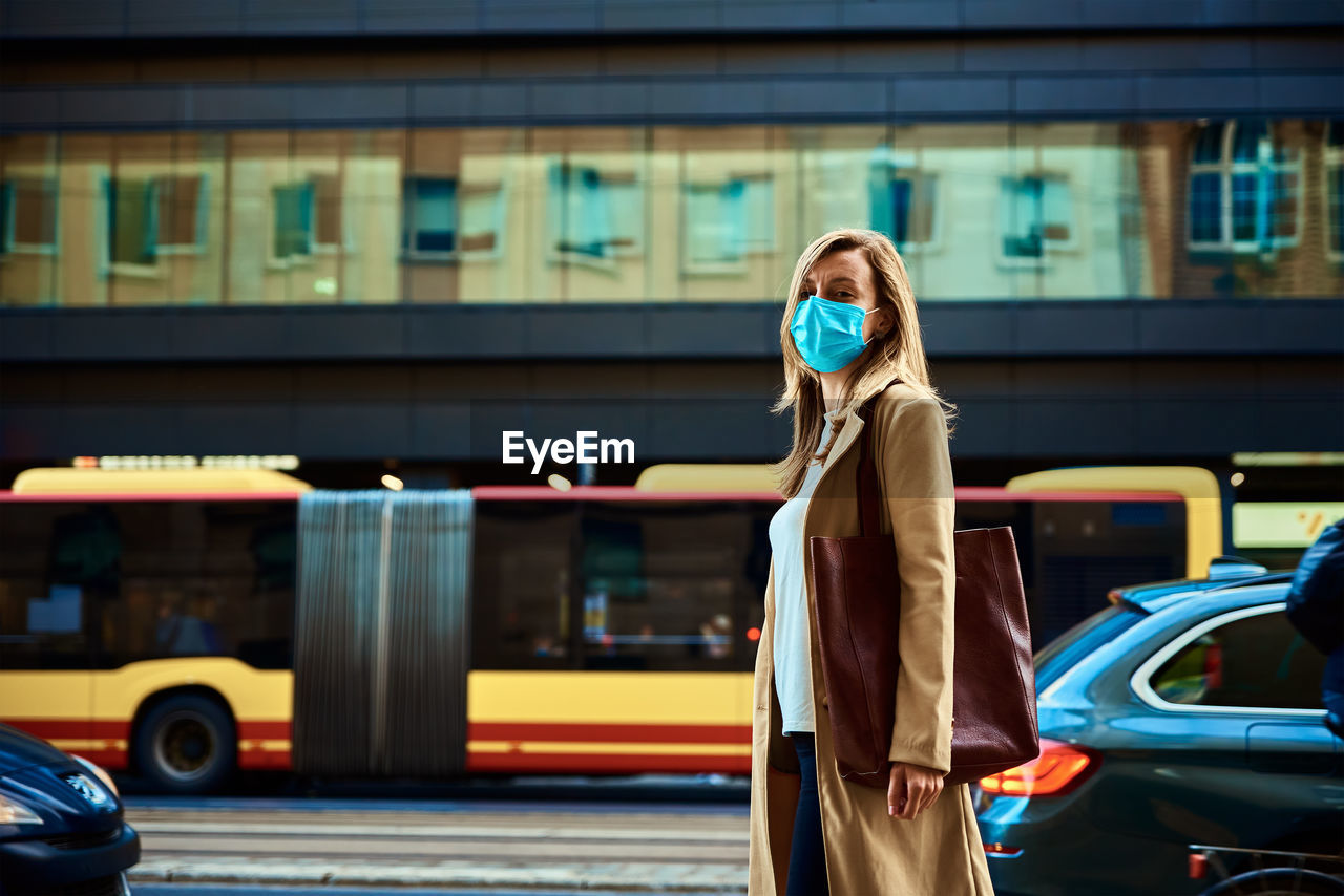 Woman in protective mask walks at city street