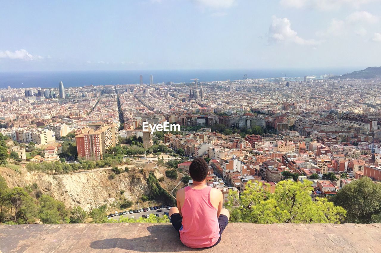 HIGH ANGLE VIEW OF WOMAN STANDING IN FRONT OF SEA