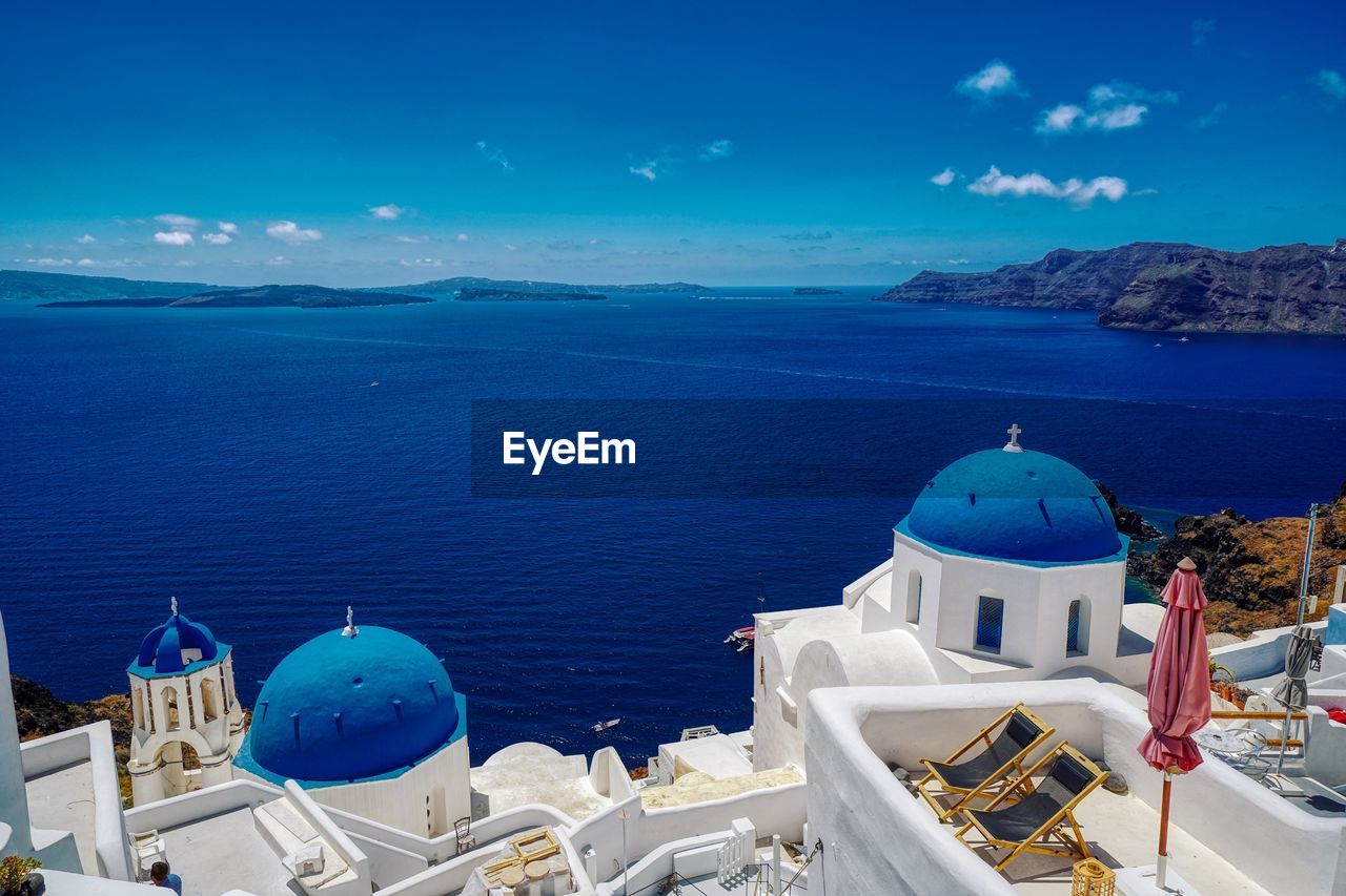 Panoramic view of sea and buildings against blue sky