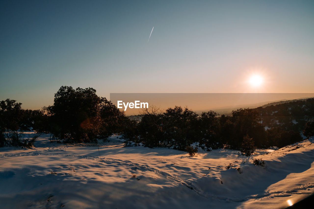 View of a beautiful snowy sunset from the train with a snowy forest. concept of a landscape of snowy