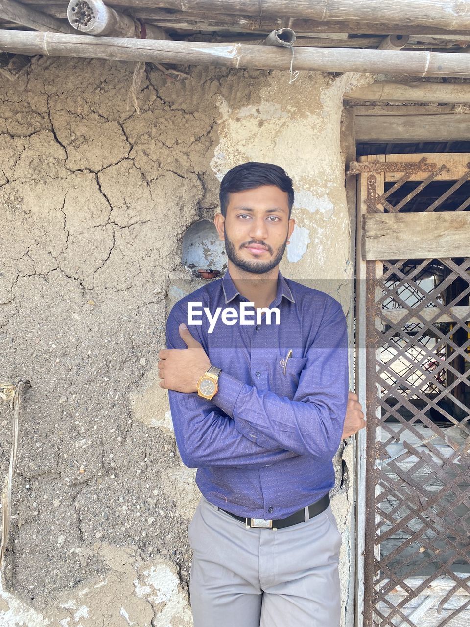 PORTRAIT OF A SMILING YOUNG MAN STANDING OUTDOORS