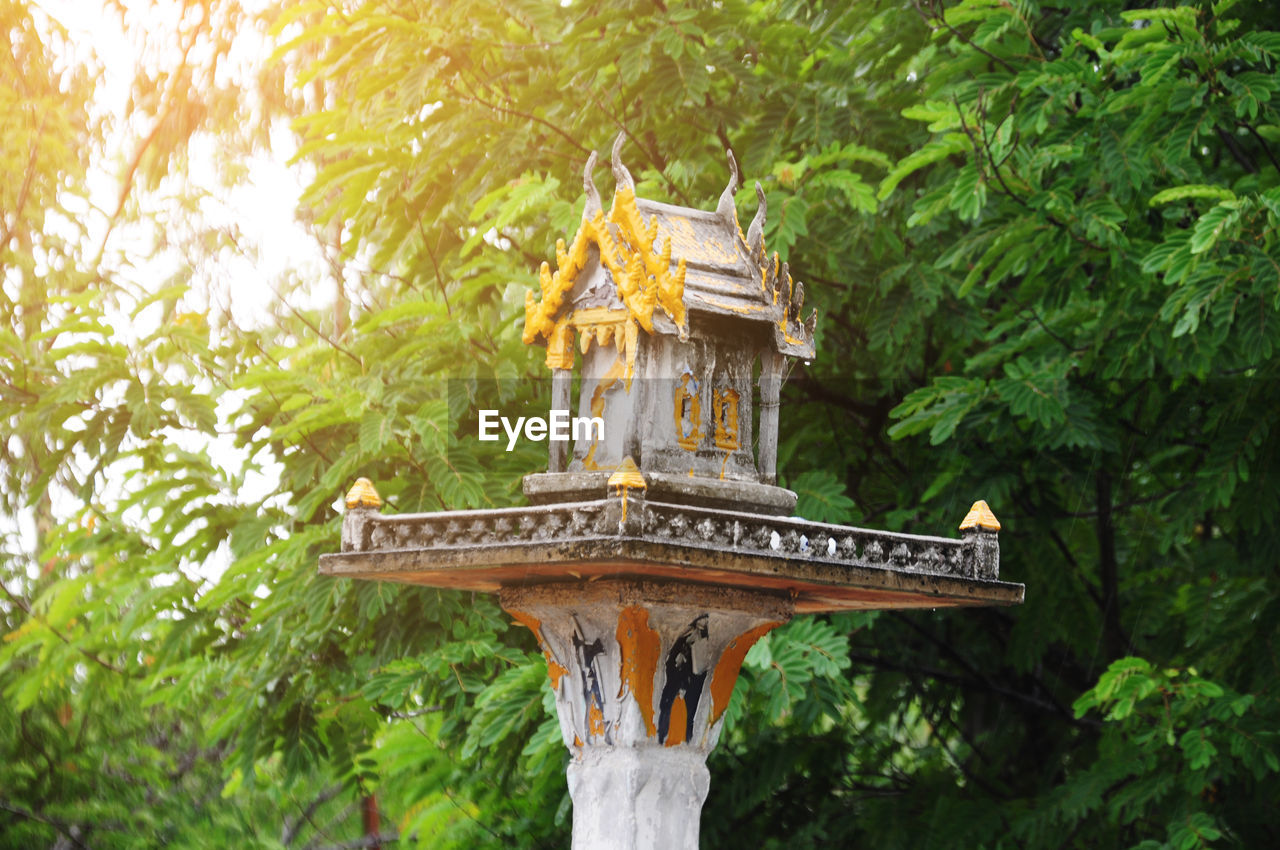 Spirit house against tree at temple