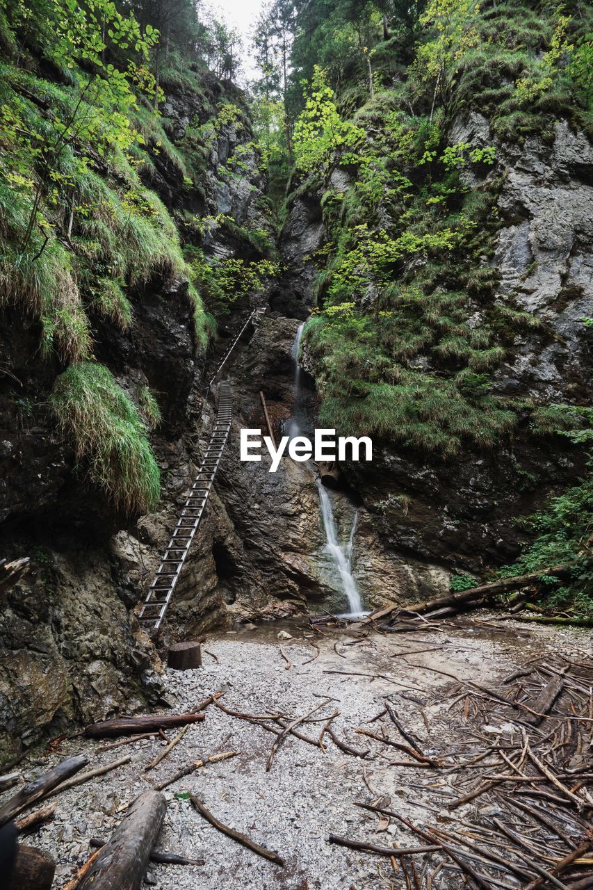 Iron stairs leading up the mountain with a waterfall beside