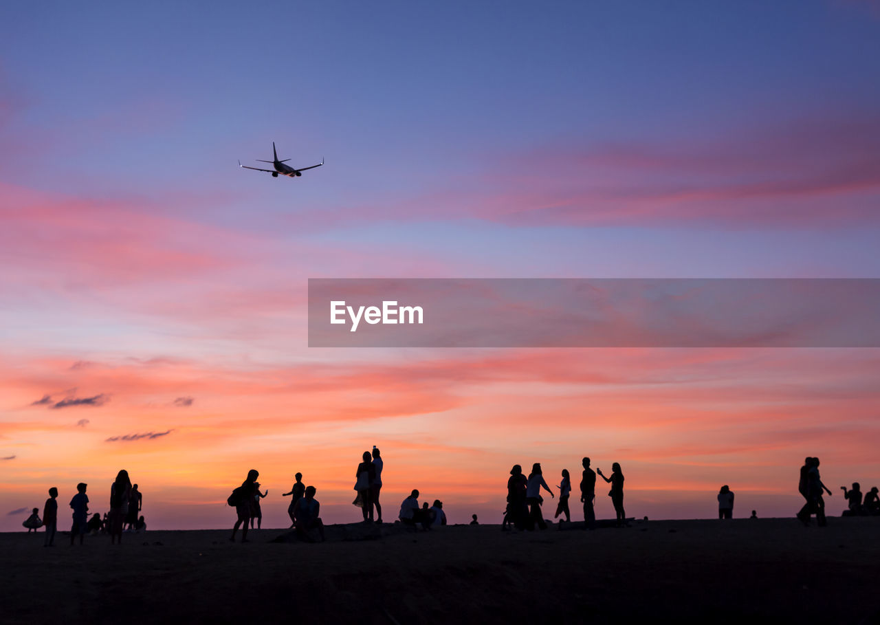 Silhouette people at beach during sunset