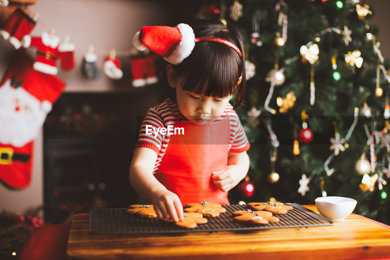GIRL LOOKING AT CHRISTMAS TREE IN TABLE
