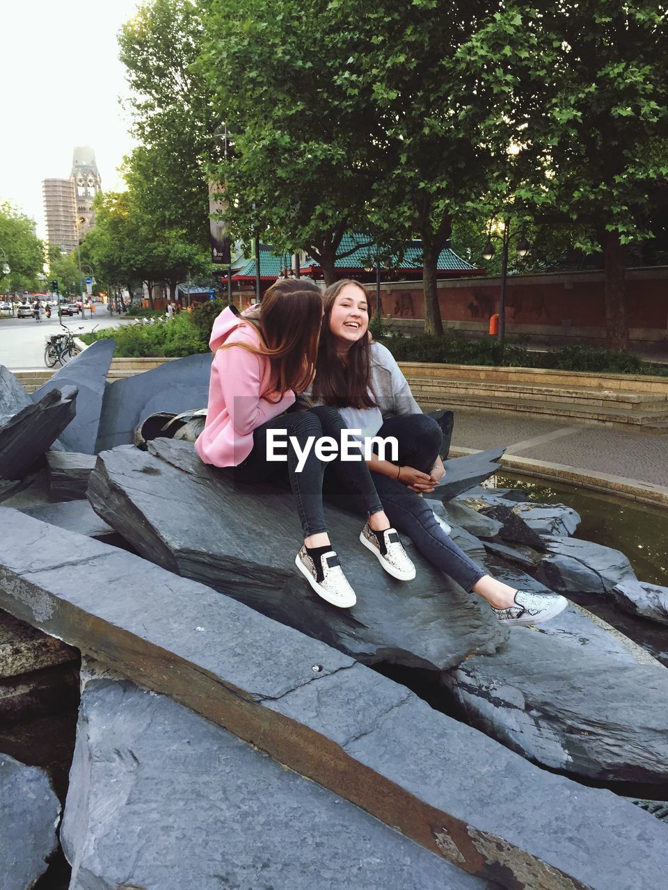 WOMAN SITTING ON SWING IN PARK