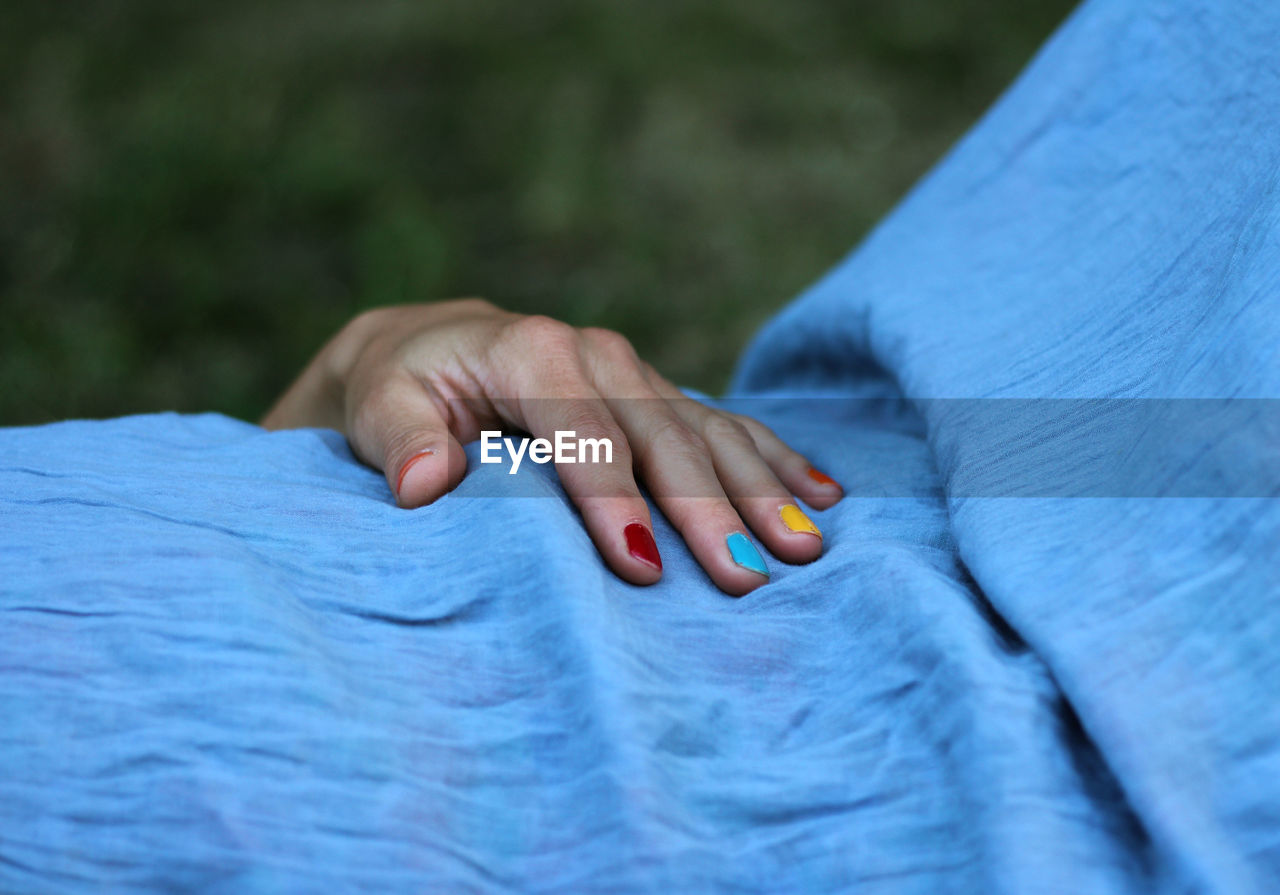 Close-up of woman with multi colored nail paint