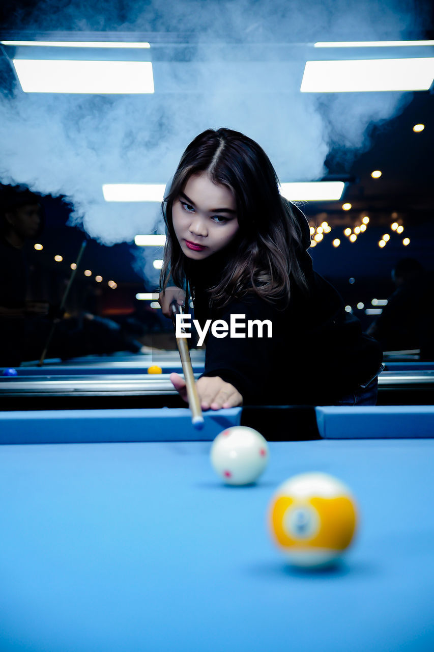 portrait of woman playing pool