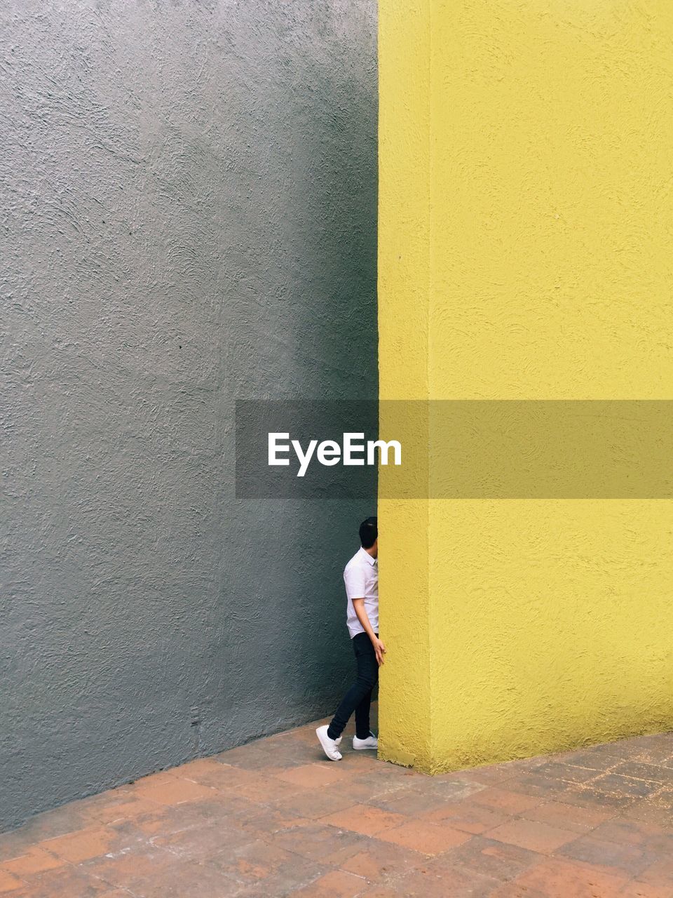 Man standing by yellow wall