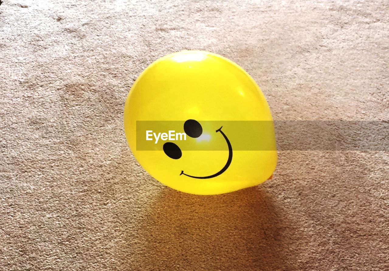 Close-up of yellow balloon on carpet