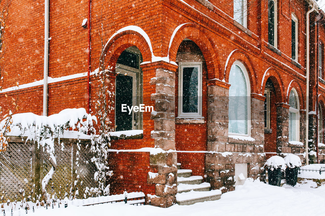 Low angle view of buildings during snowfall