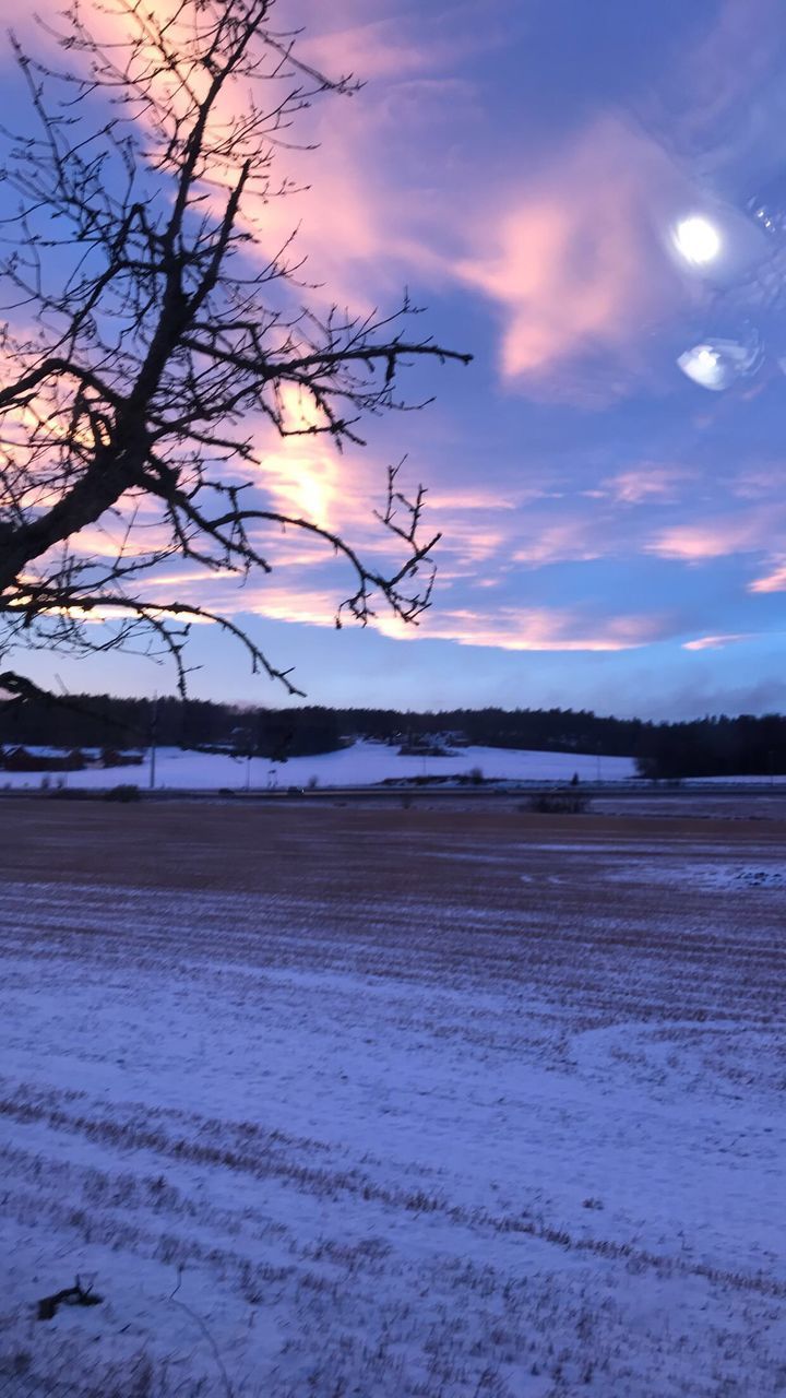 SCENIC VIEW OF SNOW COVERED LAND AGAINST SKY DURING SUNSET