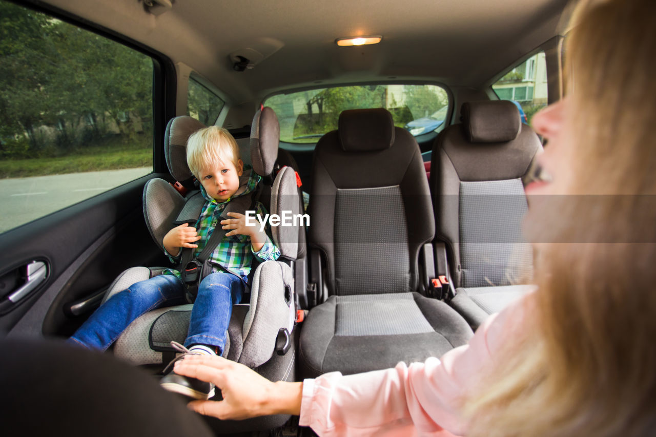 Mother and son sitting in car