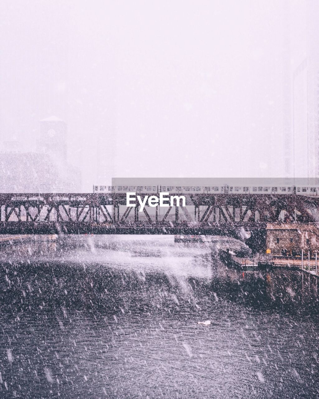 Bridge over lake against sky during winter