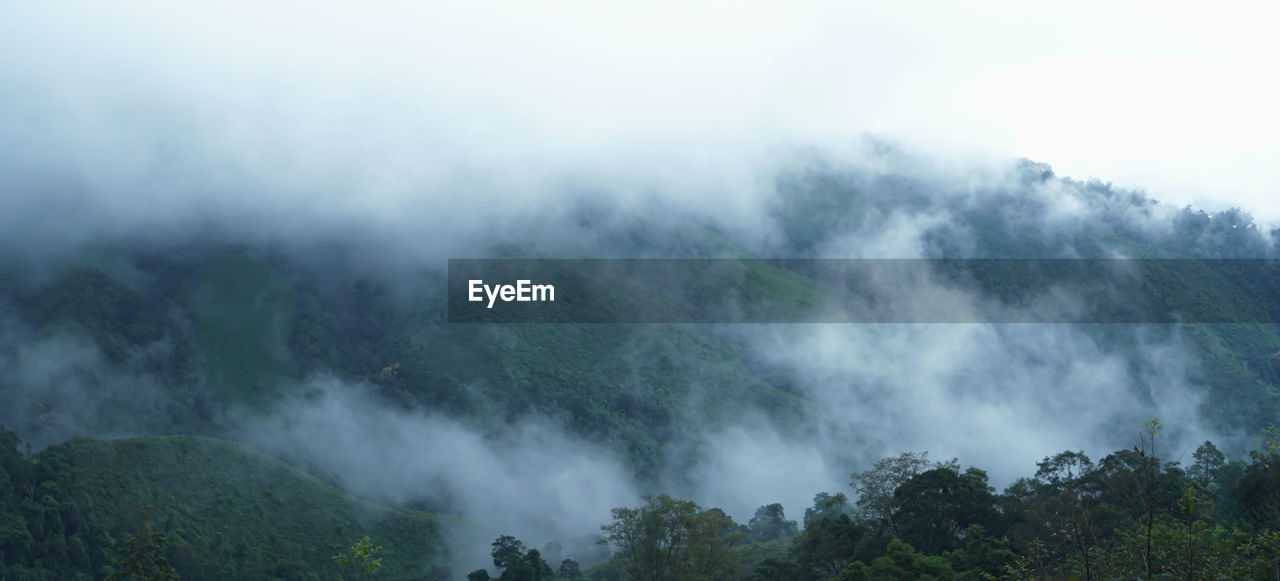 SCENIC VIEW OF FOG OVER MOUNTAINS AGAINST SKY