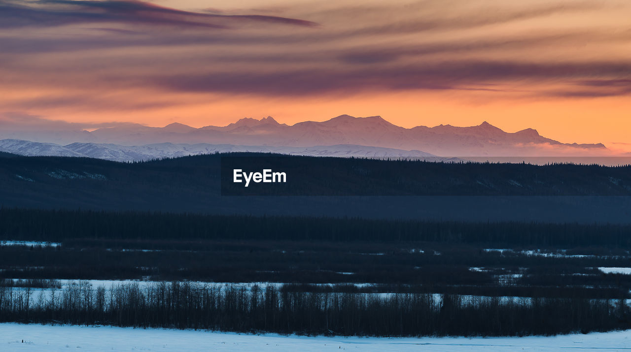 SCENIC VIEW OF SNOWCAPPED MOUNTAINS DURING SUNSET