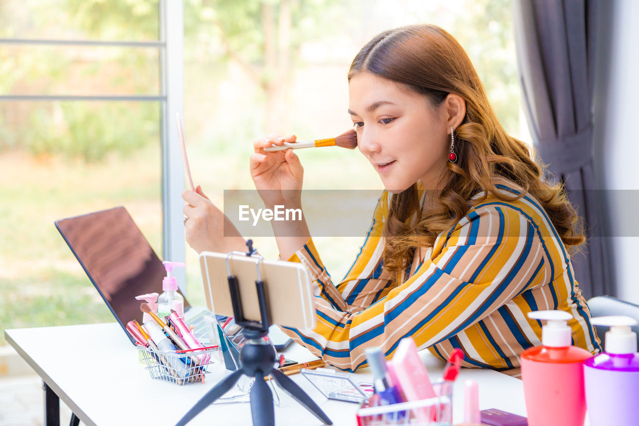 Blogger applying make-up at home