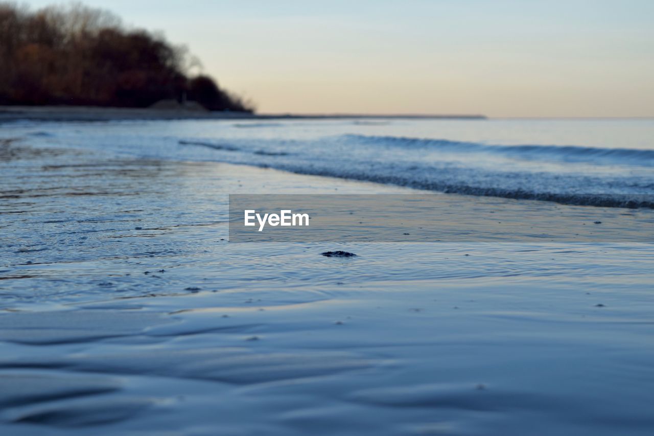 Scenic view of beach against sky at dusk