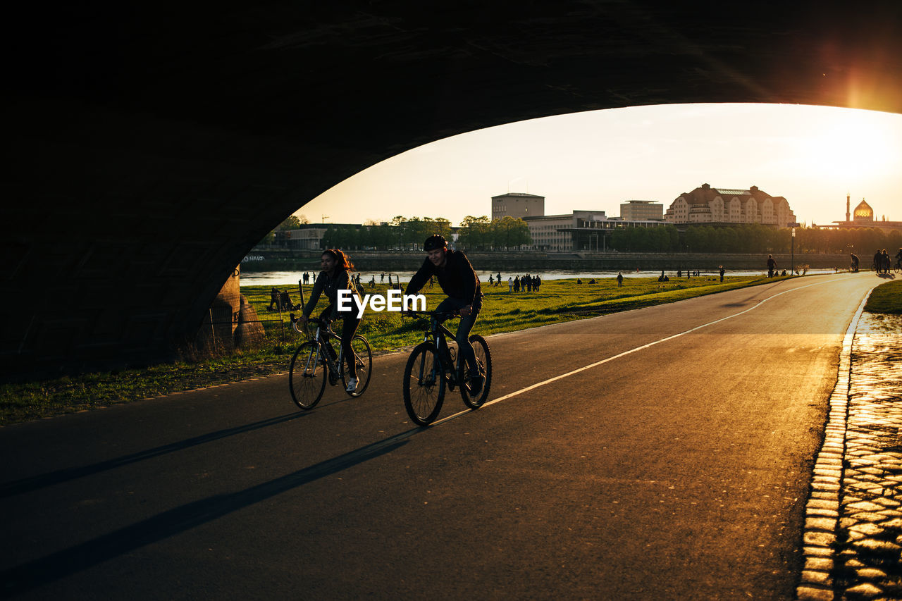 PEOPLE CYCLING ON ROAD IN CITY