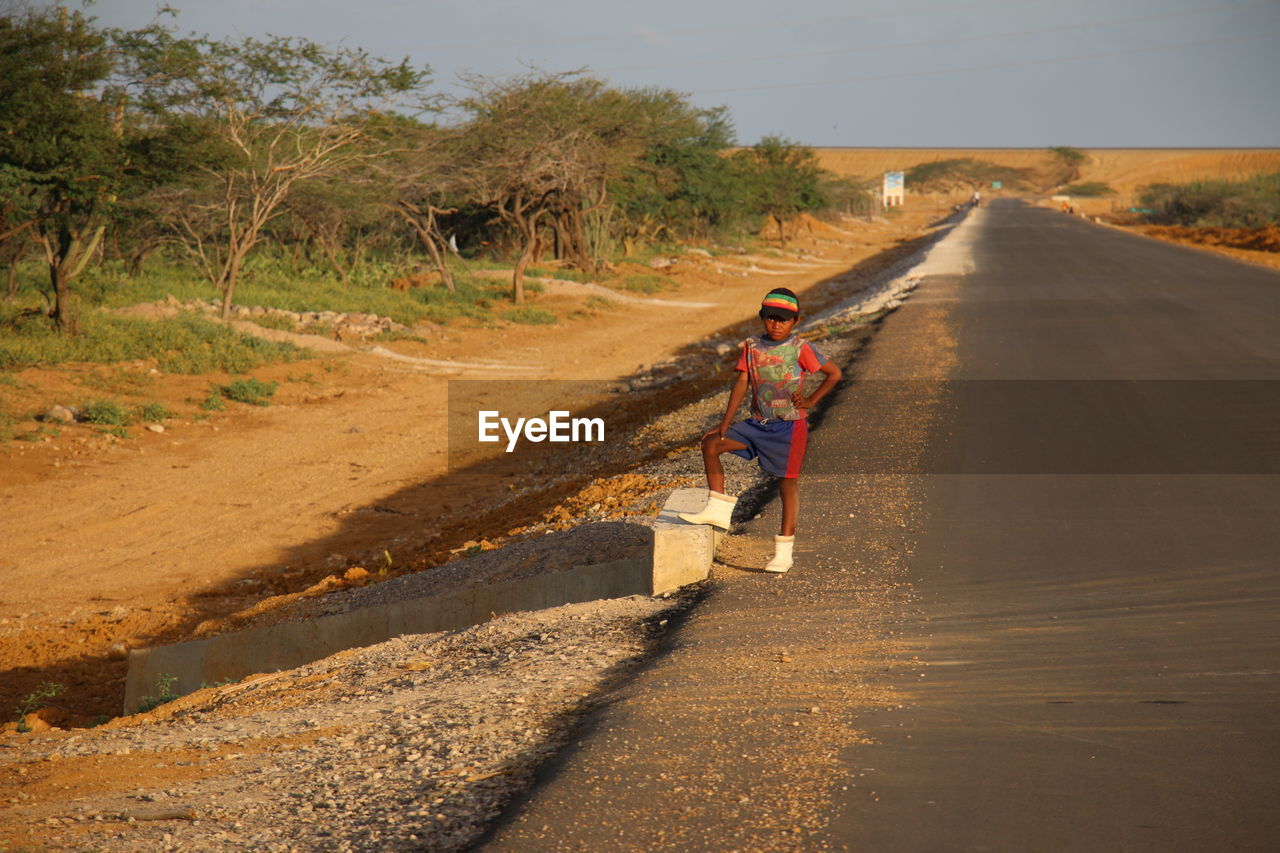 REAR VIEW OF PEOPLE RIDING ON ROAD