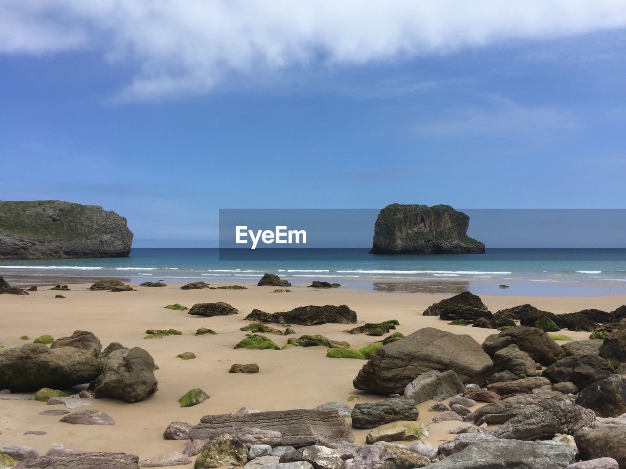 Scenic view of rocks on beach against sky