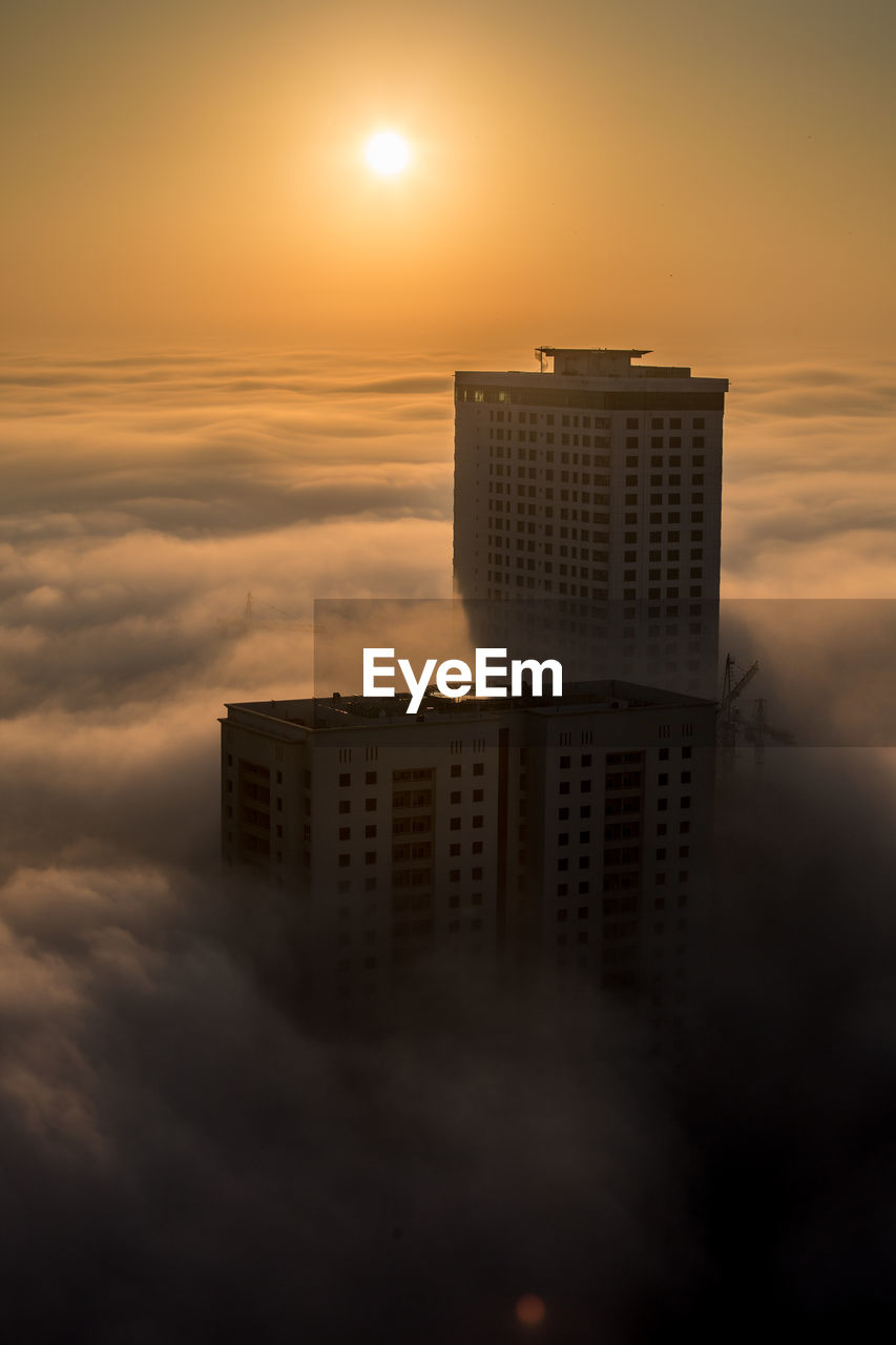 BUILDING AGAINST SKY AT SUNSET