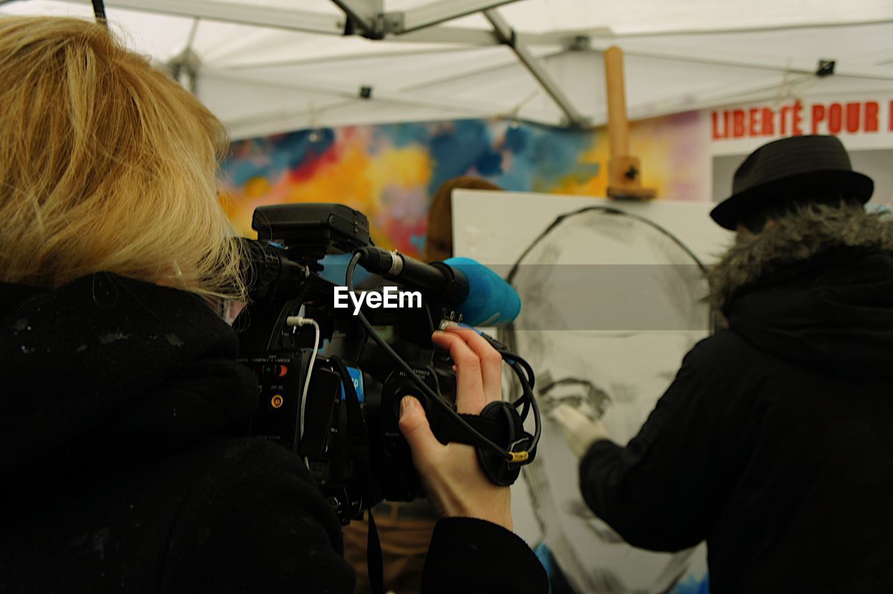 Close-up rear view of a woman with camera