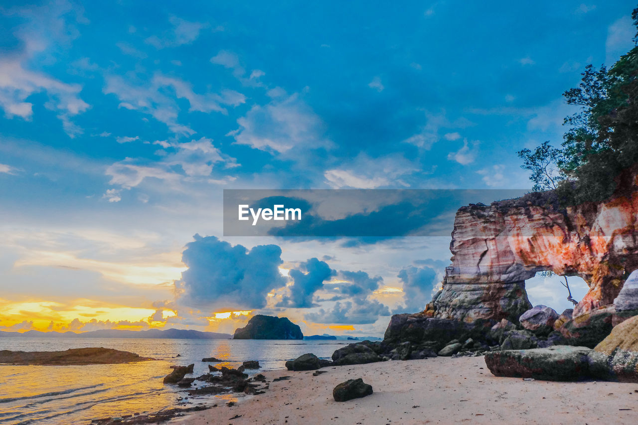 Rock formations on beach against sky