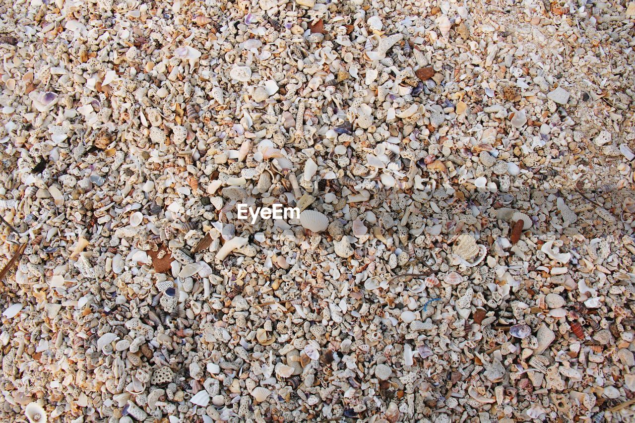 HIGH ANGLE VIEW OF STONES ON SAND