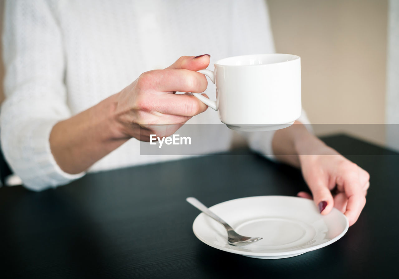 Morning cup of tea in the hands of a young woman