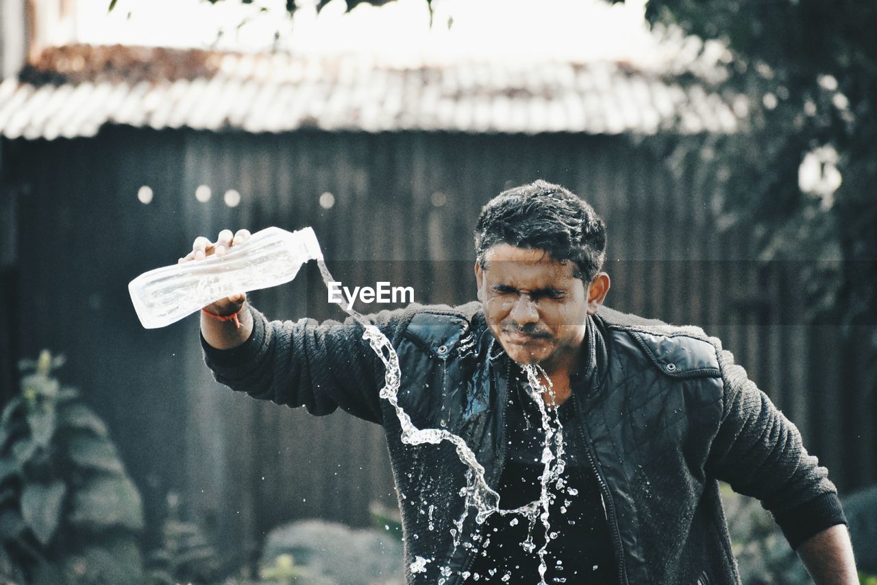 Man washing face while standing outdoors