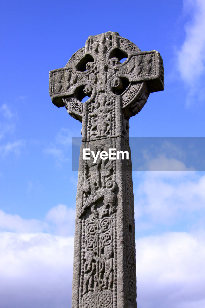 LOW ANGLE VIEW OF CROSS ON COLUMN AGAINST SKY