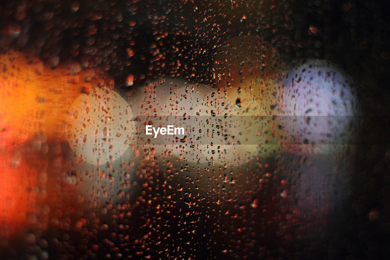 FULL FRAME SHOT OF WET GLASS WINDOW IN RAINY SEASON