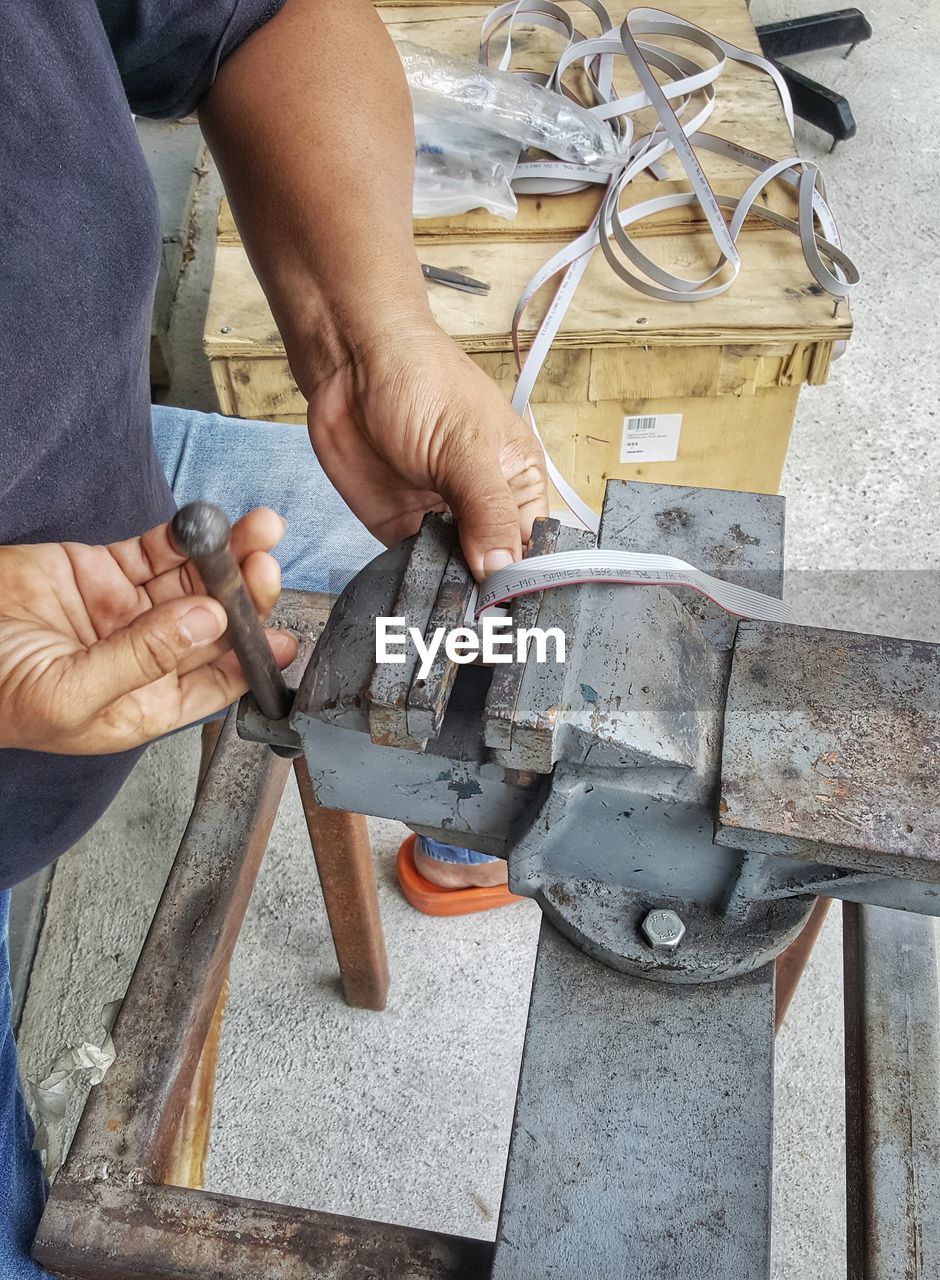 Midsection of man working on metal