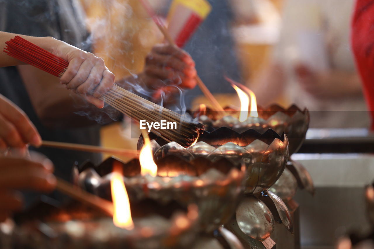 CLOSE-UP OF CANDLES BURNING IN TEMPLE