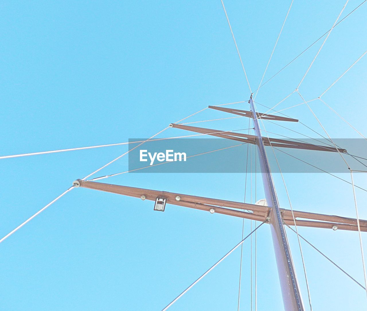 Low angle view of power lines against clear blue sky